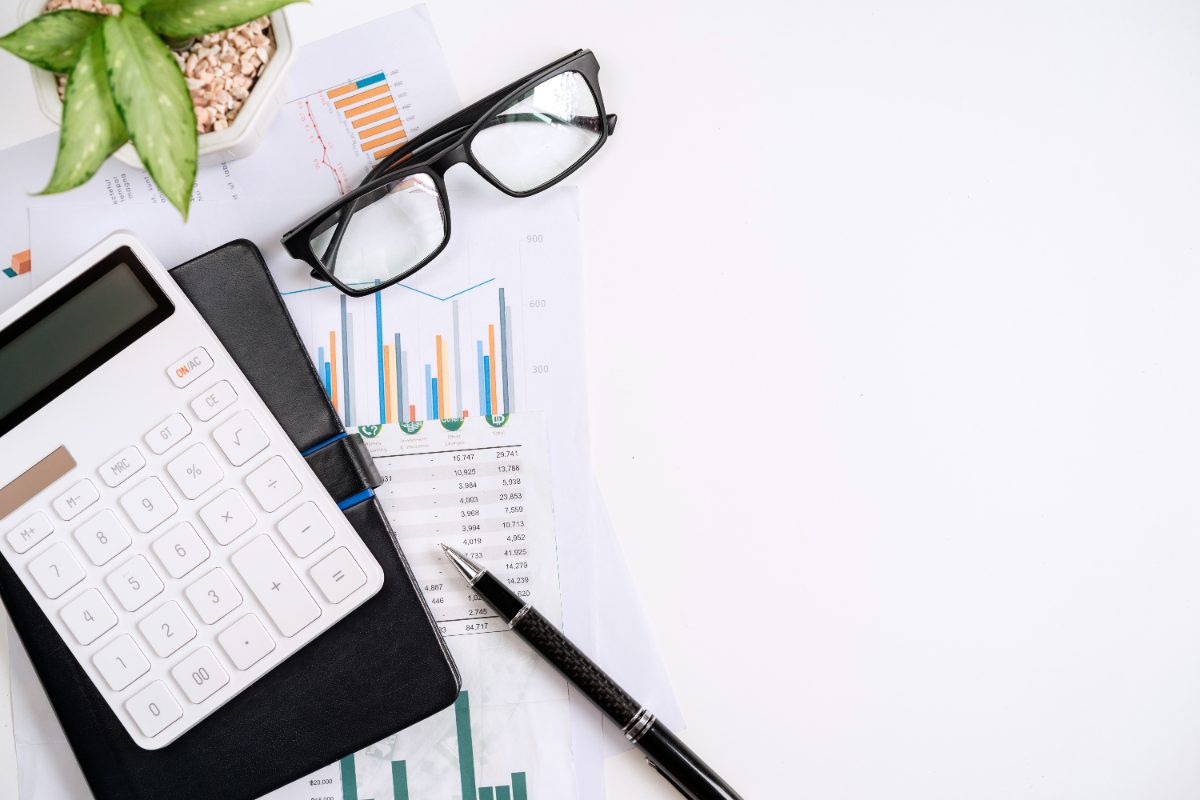 escritorio con calculadora y documentos financieros, cómo calcular el capital asegurado