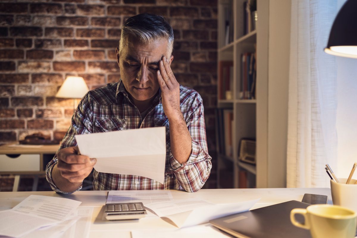 hombre preocupado revisando facturas, qué pasa si no pagas el seguro de vida