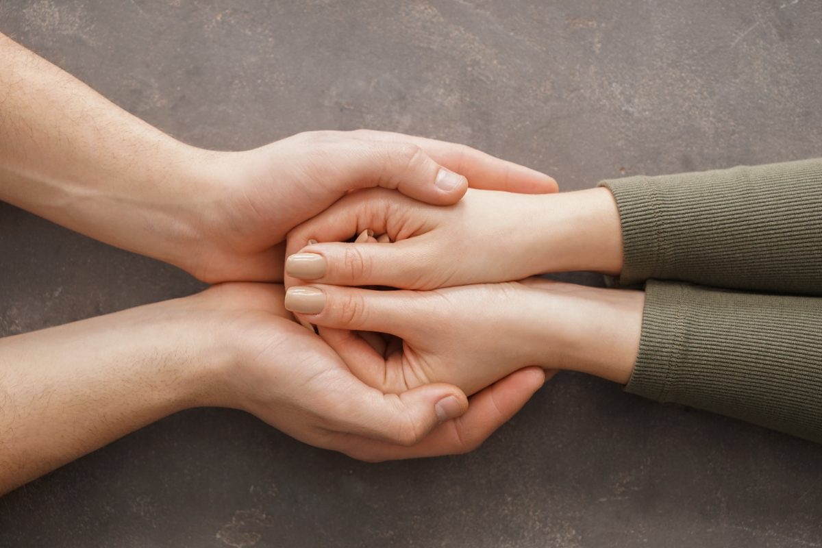 manos consolando a una persona, cómo reclamar un seguro de vida tras un fallecimiento