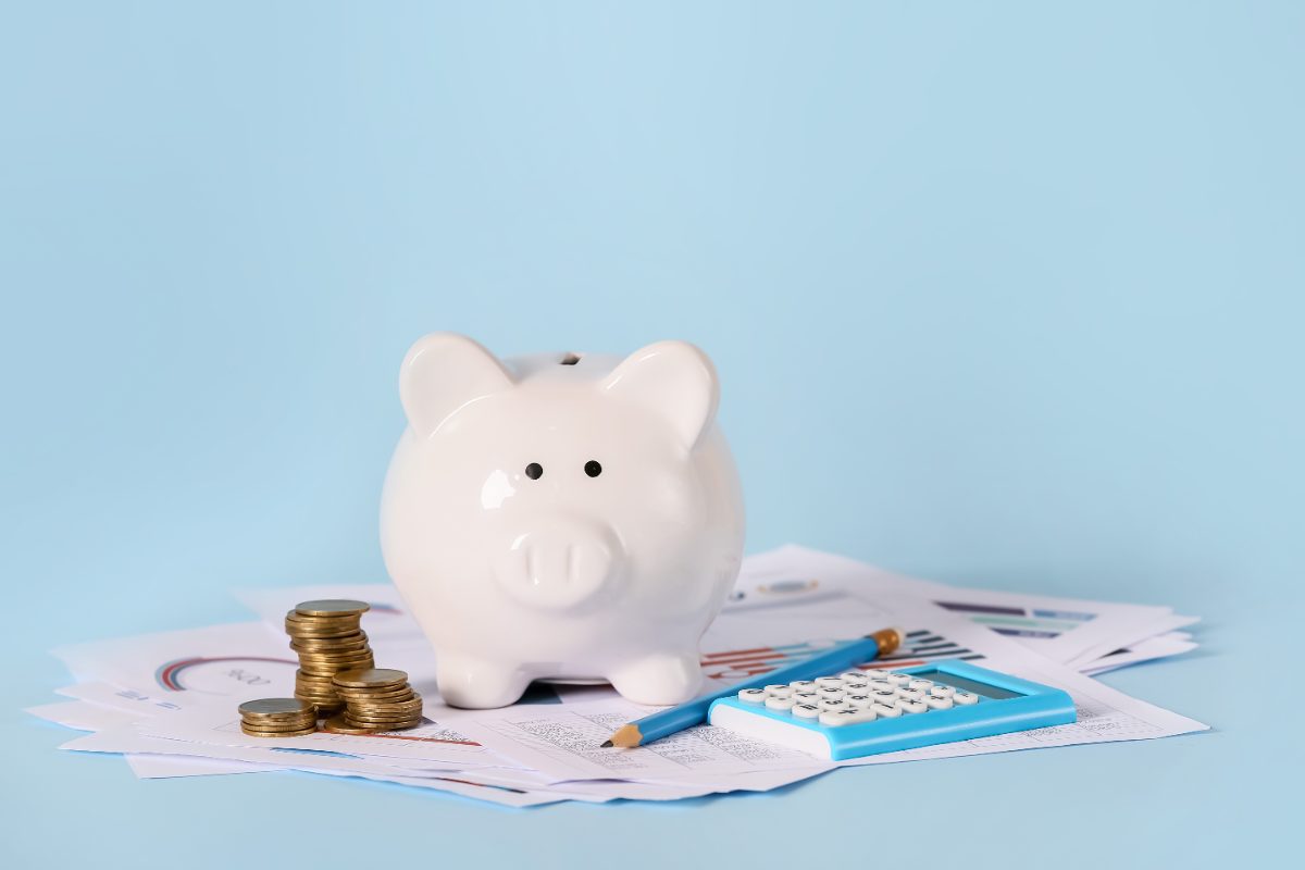 hucha con monedas y calculadora, cómo funciona el seguro de vida ahorro