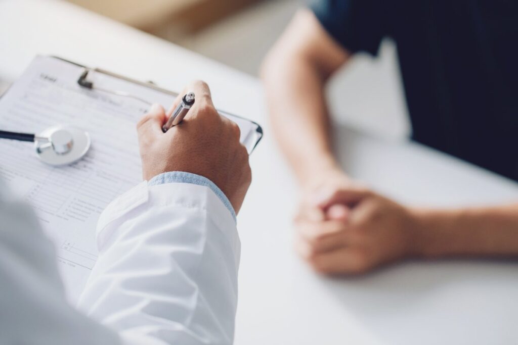 Seguro de vida con enfermedad preexistente: médico revisa el cuestionario de salud con un paciente