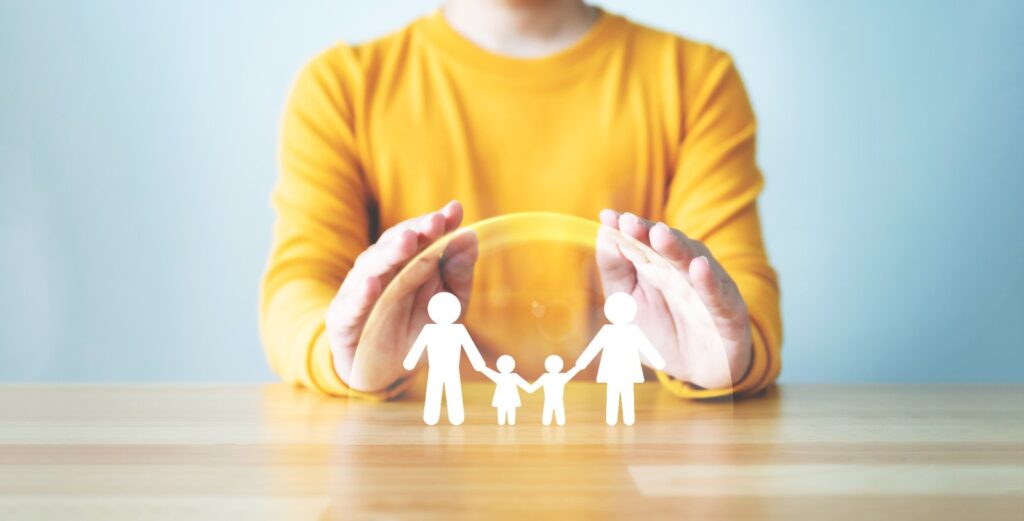 Manos protegiendo a la familia: seguro de vida y protección