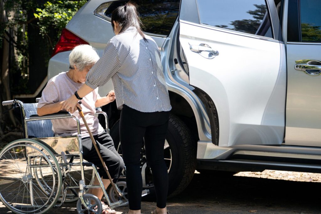 Cuidadora ayudando a una mujer mayor en silla de ruedas: seguro de vida con dependencia
