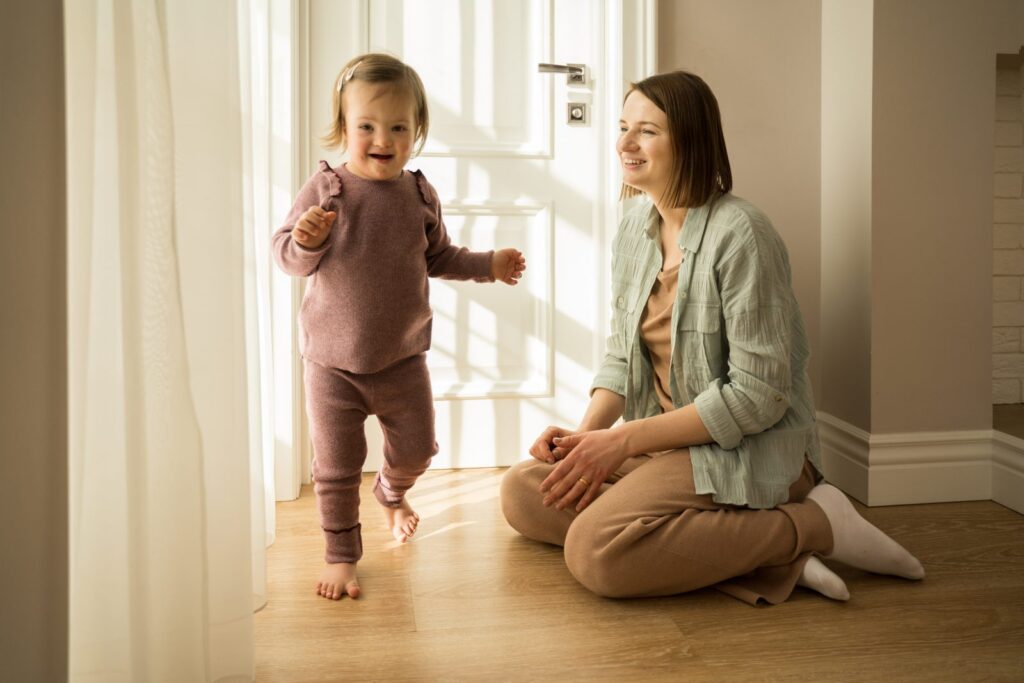 Madre jugando con su hija con síndrome de Down: seguro de vida para un hijo con discapacidad
