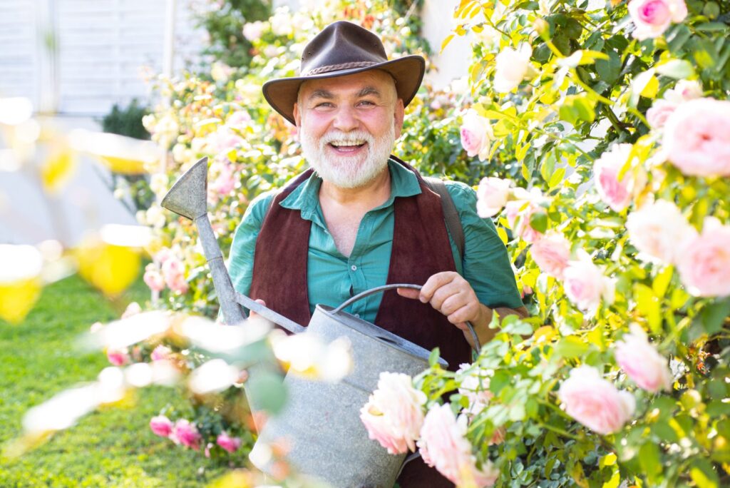 Jubilado regando rosas en el jardín: seguro de vida al jubilarse