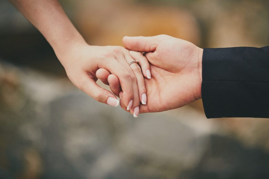 Manos de pareja con anillo: seguro de vida y régimen de gananciales